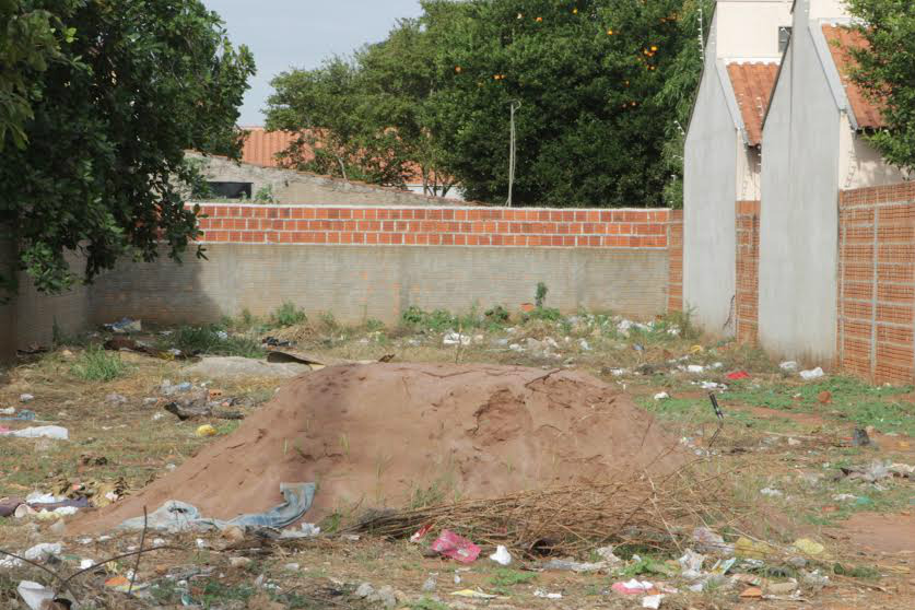 Um terreno coberto por entulhos de construção e lixo de material reciclável está murado (menos na frente) e incomodando a vizinhança (Foto: Larissa Lima) 