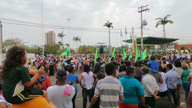 Após participar do desfile, criança nas costas do pai observa apresentação da banda marcial Cristo Redentor fazendo o encerramento da parada cívica (Foto: Ricardo Ojeda)