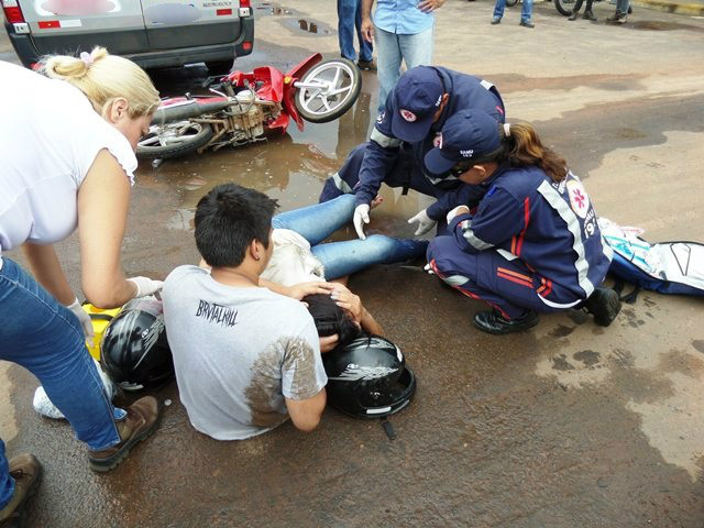 Socorristas do SAMU atendem a vítima no local do acidente; o primo da jovem a conforta, enquanto ela chora de dor na perna (foto: Celso Daniel/Perfil News)