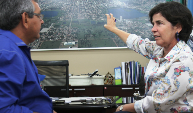 Prefeita Marcia Moura aponta na foto aérea afixada em seu gabinete o crescimento socioeconomico da cidade de Três Lagoas (Foto; Léo Lima) 