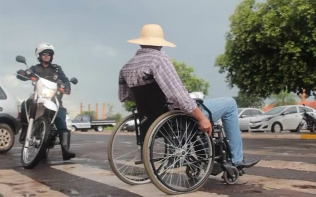 Achando que acontecia uma situação real, o policial militar que passava pelo local parou para ajudar o cadeirante atravessar a rua (Foto: Reprodução)