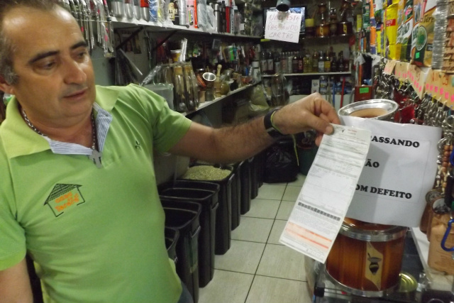 O comerciante Valmir Bessa mostra a conta de energia elétrica e também reclama do aumento da tarifa (Foto: Léo Lima)