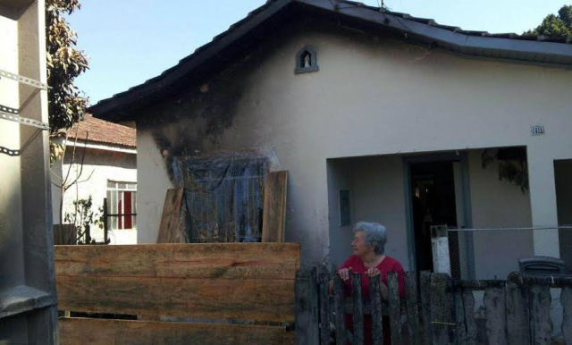 A vizinha teve a casa também atingida pelas explosão da aeronave e foi ela quem encontrou a sacola com dinheiro, queimada (Foto: Band News)