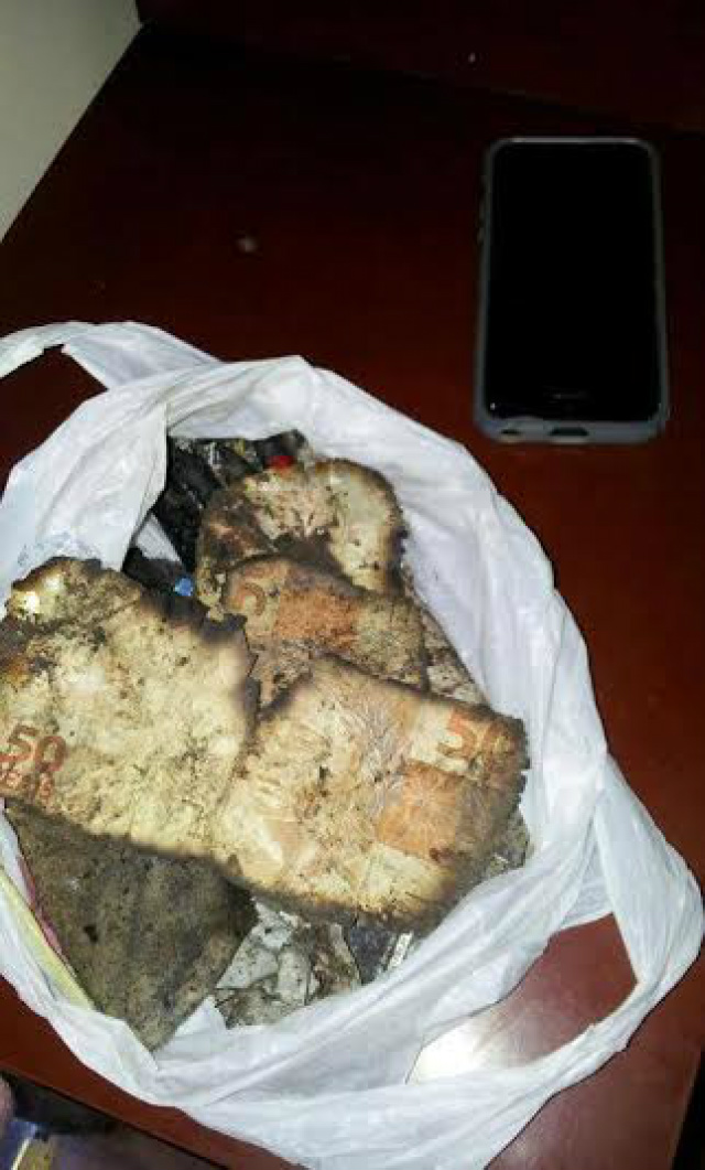 Notas de R$ 50 queimadas, entre outras cédulas, foram encontradas em uma sacola no quintal de uma casa vizinha a que foi atingida em cheio pelo avião (Foto: Band News)