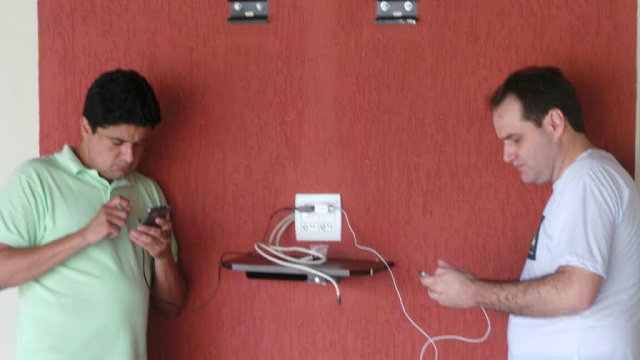 Na busca pelo voto, Atílio e Rógerson dividem tomada para recarregar as baterias dos celulares e contatar os eleitores (Foto: Ricardo Ojeda)