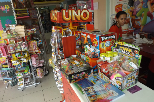 A loja já está lotada de brinquedos, mas a funcionária continua arrumando mais presentes (Foto: Léo Lima)