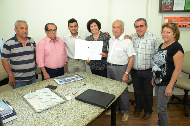 Marcia e Adolfo, na presença de membros da entidade, mostram escritura firmando a doação da área para os ferroviários aposentados (Foto: Divulgação)