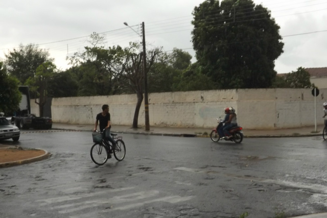 Ciclistas e ocupantes da motocicleta imprimem mais velocidade nos veículos para fugir da chuva que se anuncia, em um cruzamento de ruas no bairro Interlagos (Foto: Léo Lima)