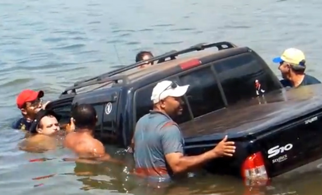 Vendo a situação desesperada do motorista, algumas pessoas entraram no rio para ajudar no resgate do veículo

