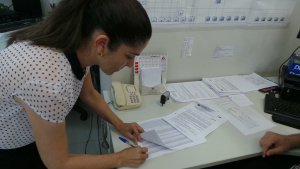 a juíza Daniela Peruca assina a planilha com os nomes dos trabalhadores beneficiados na ação (Foto: Ricardo Ojeda)