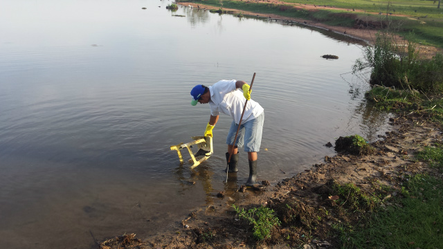 Demilson Chagas recolhe um banco de plástico jogado por inconsequente frenquentador dentro da Lagoa Maior (Foto: Ricardo Ojeda) 