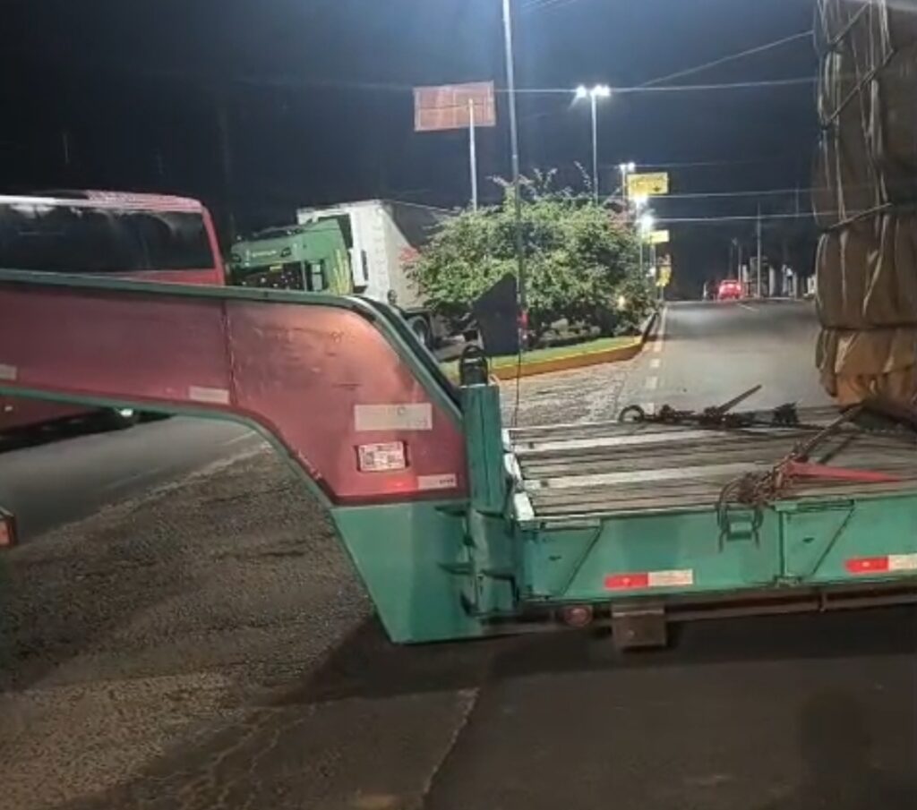 Carreta com carga superdimensionada fica presa em quebra-mola no centro de Água Clara