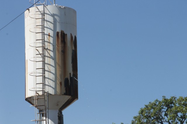 Mato toma conta da calçada da escola João Ponce e caixa d’água tem vazamento constante