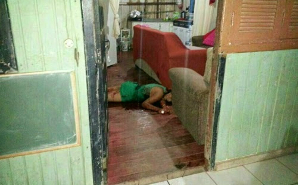 Corpo da cantora caído na sala da casa onde ela morava, coberto de sangue pelas dez facadas (Foto: Hoje News)