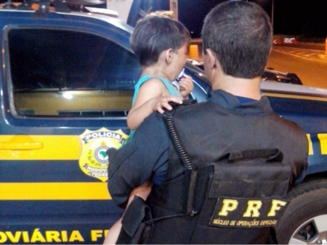 Policial da PRF consola criança assustada após pai fugir de blitz em alta velocidade A criança estava no colo do policial, que a acalmou após a situação. (Foto: Assessoria)