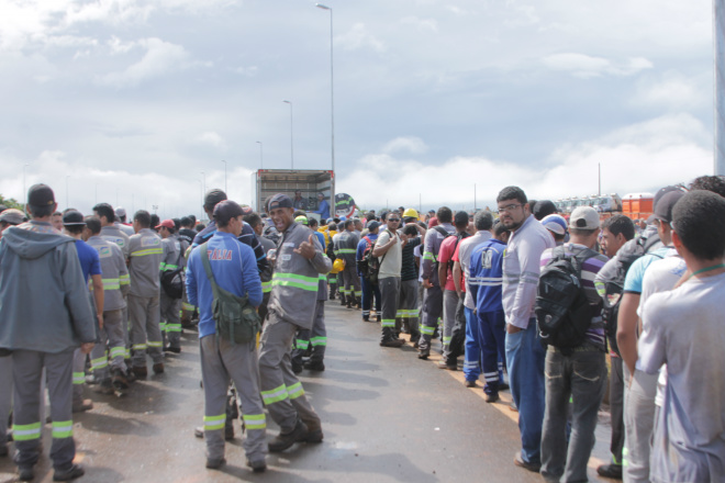 Tralhadores que aderiram ao movimento grevista ficam na fila para receber lanche distribuído em frente do portão do complexo onde está sendo construída a fábrica de fertilizantes da Petrobras (Foto: Ricardo Ojeda)  