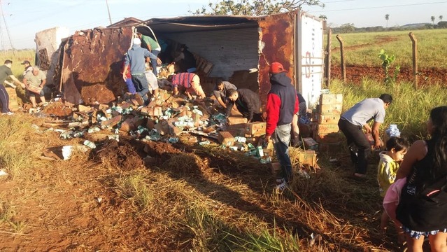 Caminhão com leite tomba, empresa libera carga e moradores aproveitam Muita gente aproveitou para pegar leite — Foto: Osvaldo Nóbrega/TV Morena