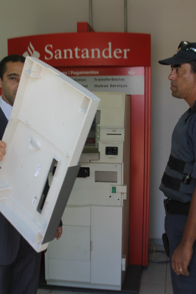 Caixa eletrônico do Santander amanhece arrombado em Três Lagoas
Policial militar atende ocorrência de arrombamento do terminal eletrônico do Santander, enquanto funcionário da agencia verifica os estragos no equipamento (Foto: Ricardo Ojeda)