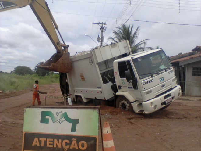 Uma escavadeira foi utilizada para tirar o caminhão de lixo que ficou atolado em um bairro da periferia de Três Lagoas (Foto: Adilson Nogueira)