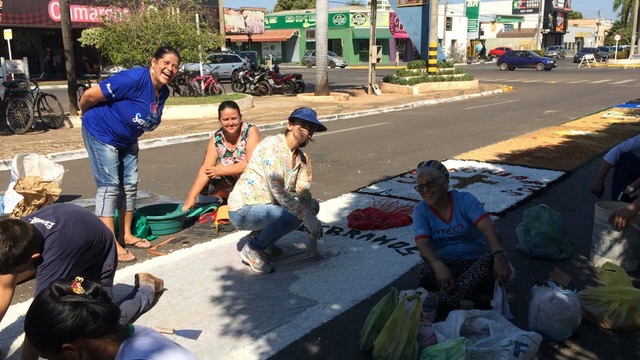 Tapete de Corpus Christi enche o centro da cidade de cor e fé Dona Marta (sentada no chão, de camiseta azul) participa da confecção do tapete há dez anos.