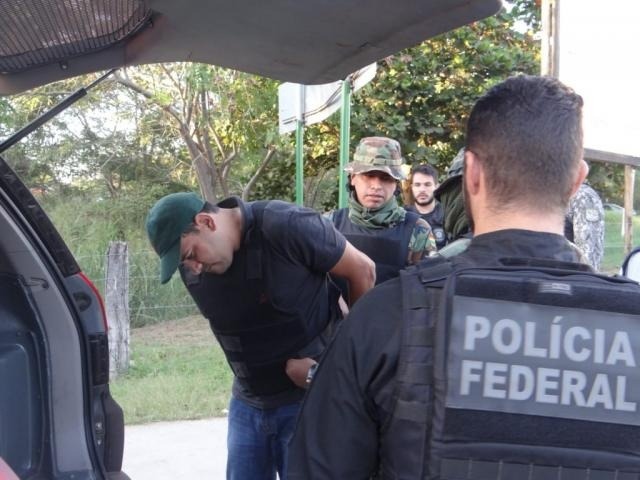 Bolívia entrega em MS condenado por assassinato e tráfico extraditado Brasileiro detido sendo colocando em viatura policial (Foto: Divulgação/Polícia Federal)