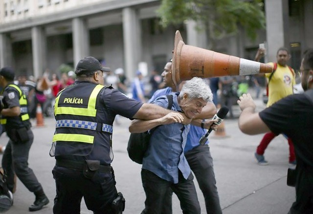 Servidores atiraram um cone no jornalista, enquanto era retirado por policiais. (Foto: Alex Ribeiro)