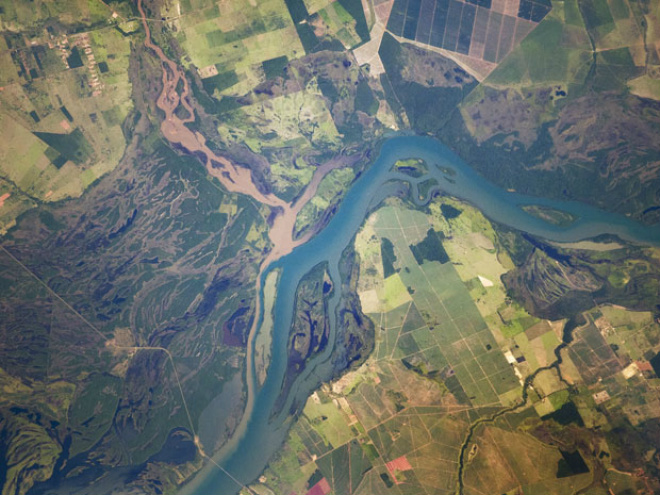 Imagem mostra o Rio Paraná, em tons azuis, e o Rio Verde, de cor marrom, na divisa de Mato Grosso do Sul com São Paulo (Foto: M. Justin Wilkinson, Jacobs/ESCG at NASA-JSC)