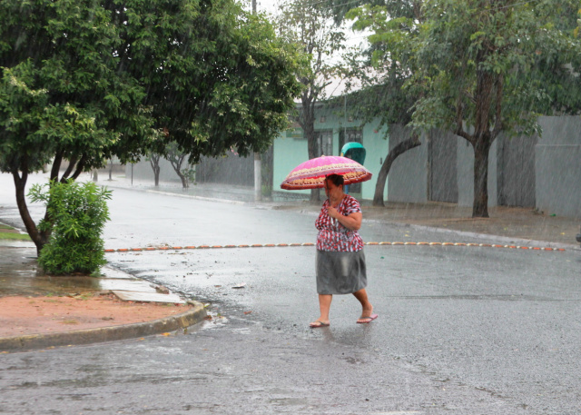 Fim de semana prolongado em Três Lagoas será de chuva e altas temperaturas Moradora usa um guarda-chuva para se proteger. (Foto: Lucas Gustavo).