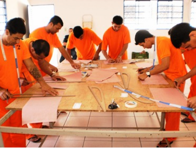 Internos do presídio de Rio Brilhante, uniformizados, participam de curso de corte e costura (Foto: Divulgação)