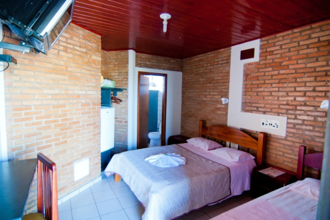 A pousada possui apartamento com ar, frigobar e TV e localização privilegiada para a piscina e para o rio (Foto: Divulgação)