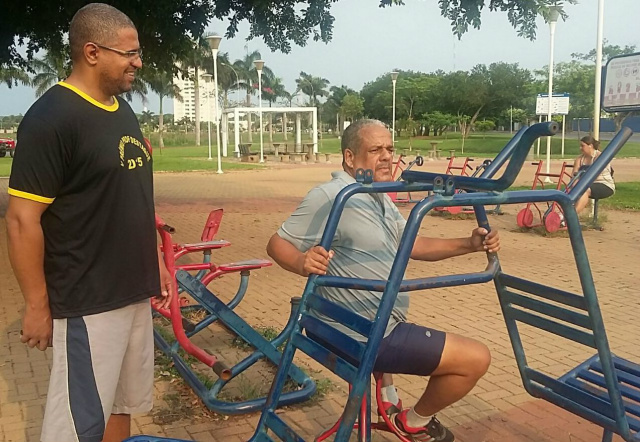 O professor de Educação Física, Daniel Alves de Souza, auxilia Seo Moreira nos exercícios físicos. (Foto: Patrícia Miranda) 