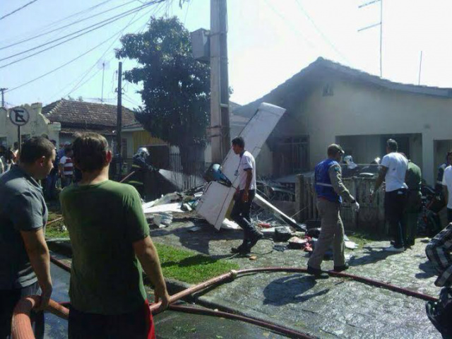 Pessoal do resgate e vizinhos do local onde o avião caiu trabalham para socorrer vítimas e controlar o fogo (Foto: Band News)