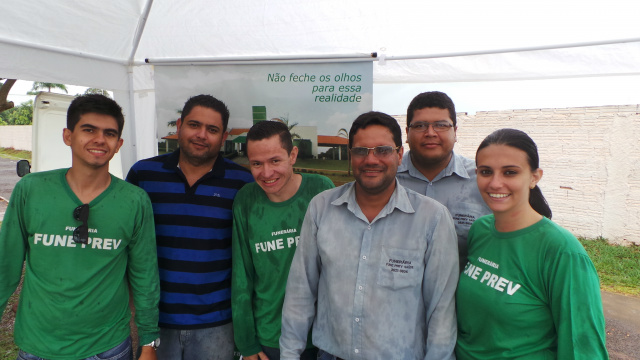 Equipe de uma empresa funerária, mesmo sobre chuva, marcaram presença na entrada do cemitério para distribuir folhetos publicitário do empreendimento póstumo. (Foto: Ricardo Ojeda)  