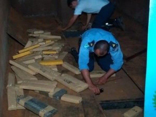 Policiais retirando a droga do assoalho do caminhão. (Foto: Adilson Domingos)
