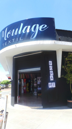 Facha da loja que comercializa tecidos enfeitou a frente da vitrine com uma faixa de protesto 