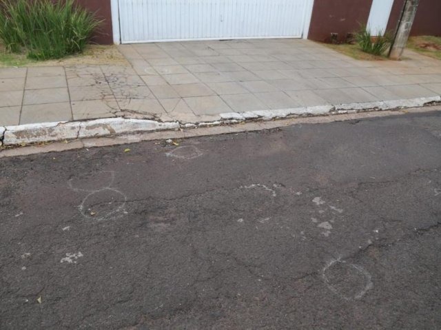 Marcas no asfalto indicam a quantidade de munições encontradas em frente à casa (Foto: Paulo Francis/Campo Grande News)
