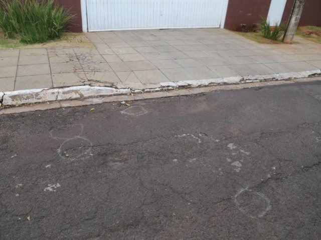 Empresário de mineração é executado e filho baleado por atiradores em carro Marcas no asfalto indicam a quantidade de munições encontradas em frente à casa (Foto: Paulo Francis/Campo Grande News)