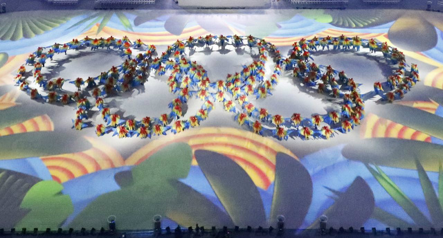Anéis Olímpicos, símbolo dos jogos, formados por voluntários vestidos de araras, que representa fauna brasileira, durante cerimônia de encerramento dos Jogos (Foto: Divulgação)