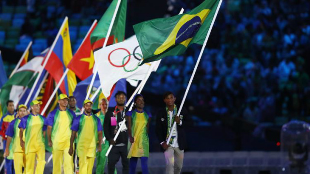 O medalhista Olímpico Isaquias Queiroz, que conquistou três medalhas durante os jogos, carrega a bandeira do Brasil durante a cerimônia de encerramento (Foto: Divulgação/UOL) 