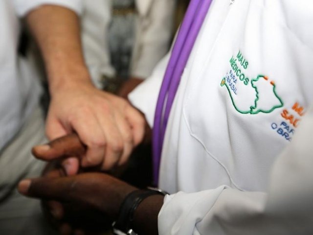 Com 115 vagas para MS, ministério lança novo edital do Mais Médicos Profissional do Mais Médicos de mãos dadas com paciente (Foto: Karina Zambrana /ASCOM/MS)