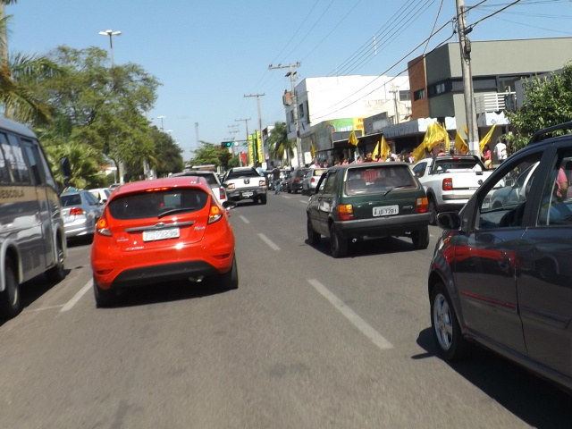 Cabos eleitorais agitam bandeiras em frente a um comitê de candidato, no centro da cidade (Foto: Léo Lima)