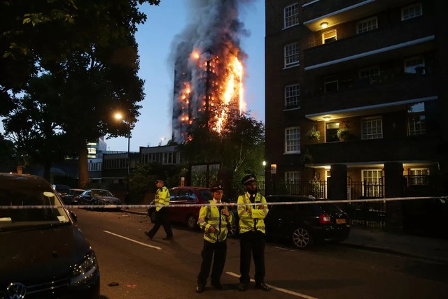 Policiais isolam área próxima ao prédio em chamas durante o amanhecer em Londres (Foto: Daniel Leal-Olivas/AFP)