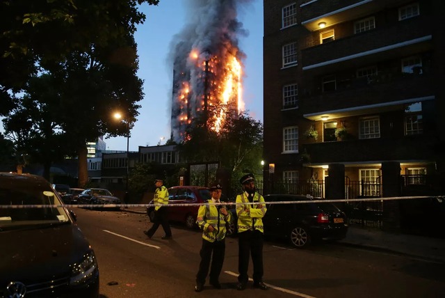 Incêndio atinge prédio de 24 andares e deixa 6 mortos em Londres Policiais isolam área próxima ao prédio em chamas durante o amanhecer em Londres (Foto: Daniel Leal-Olivas/AFP)