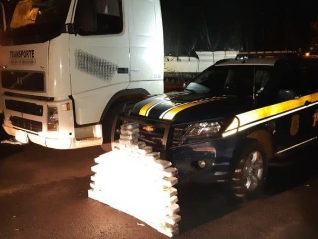 PRF apreende 103 quilos de cocaína que seriam levados de MS para MG Caminhão onde a droga era transportada ao lado dos tabletes e viatura da PRF. (Foto: Divulgação/PRF)