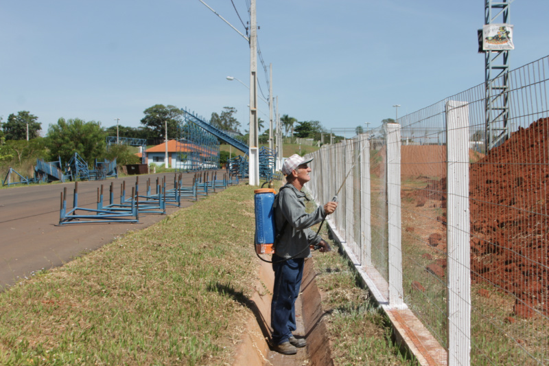 Operário pinta o alambrado que separa a pista das arquibancadas, no Arena Mix (Foto: Léo Lima)