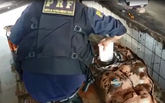 Dois são presos em MS com cocaína escondida em tanque de combustível de caminhonete Cocaína é retirada de tanque de combustível (Foto: PRF/Divulgação)