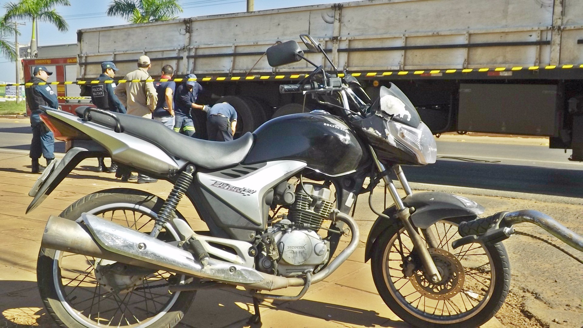Morre jovem que se envolveu em acidente com carreta em Três Lagoas Moto que o jovem conduzia e, aos fundos, carreta em que ele ficou debaixo. (Fotos: Lucas Gustavo/ Perfil News).