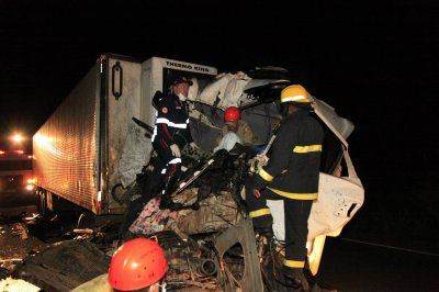 Carreta bate em outra e menina de três anos acaba morrendo Bombeiros tentam resgatar corpo da menina, que ficou preso às ferragens da carreta (Foto: Edição de Notícias)