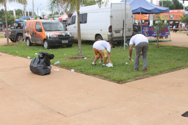 Pessoal da limpeza cata papéis, sacos e garrafas plásticas em um dos locais onde existem lixeiras à disposição dos usuários do Arena Mix (Foto: Léo Lima/Perfil News)