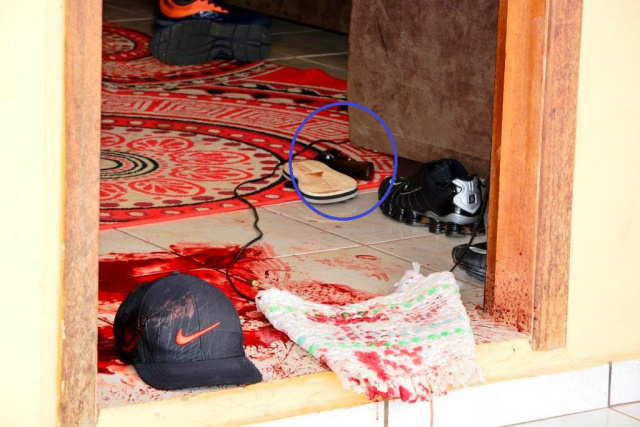 O rapaz foi atingido na sala, que ficou cheia de sangue. No circulo a arma que ele apontou para os policiais(Foto: Cenário MS) 